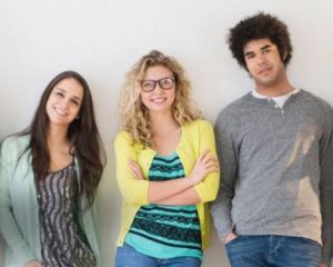 Young adults leaning against wall