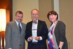 Dr. Irwin poses for a photo holding his MCHB Title V Lifetime Achievement Award